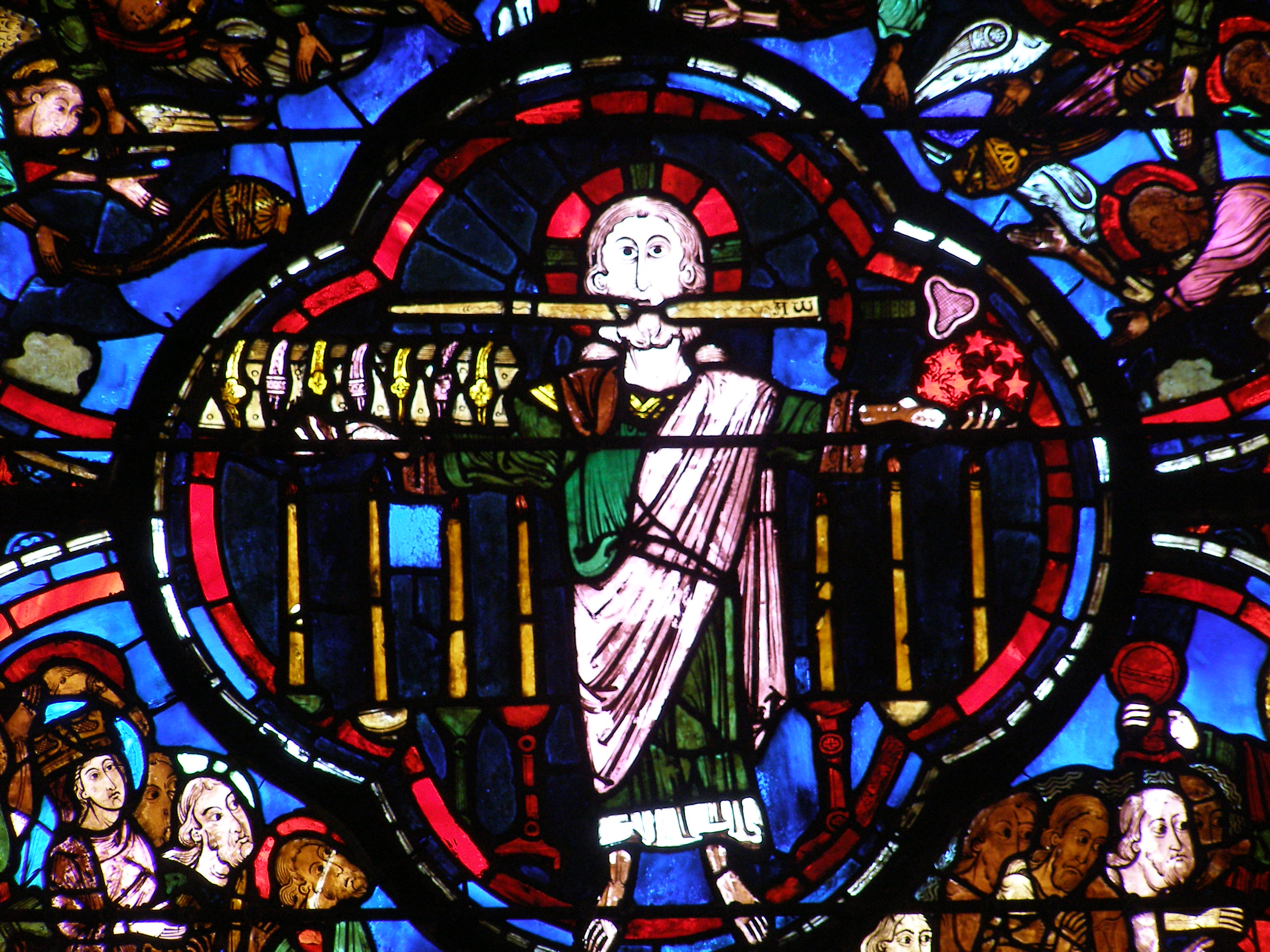 Le Christ tenant le livre aux 7 sceaux et les 7 étoiles, debout devant les 7 chandeliers – Vitrail de l’Apocalypse,  Cathédrale de Bourges.